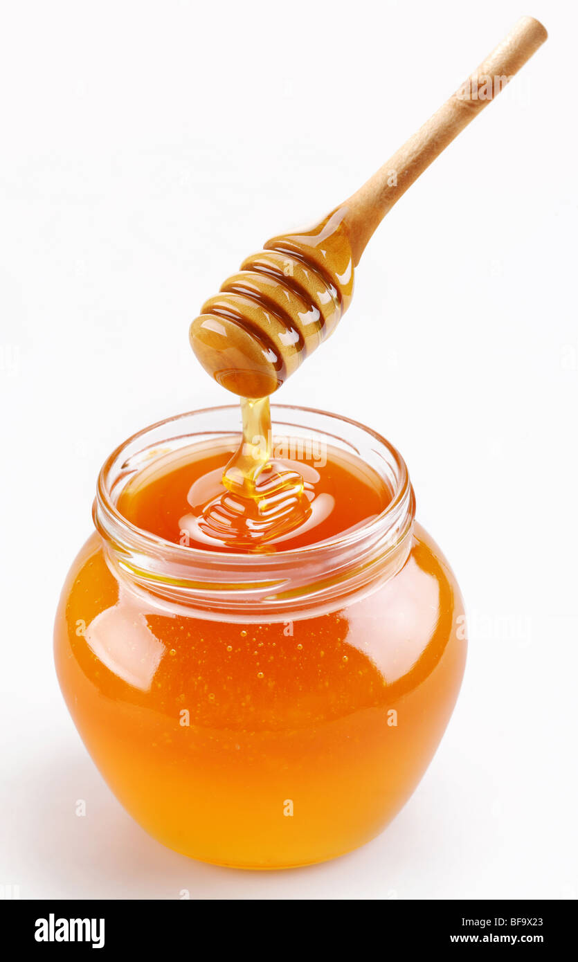Full honey pot and honey stick Stock Photo