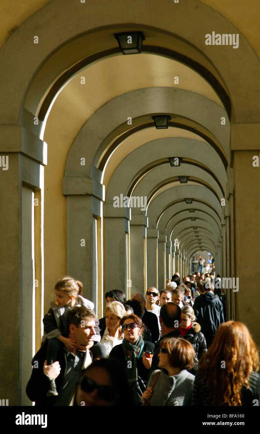 Crowds walks through the arches of the Corridoio Vasariano or Vasari Corridor a passageway in Florence Italy Stock Photo