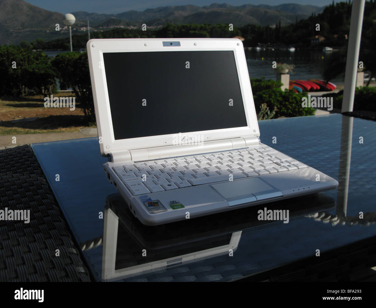 Asus Eee 1000 ten inch screen wifi netbook laptop personal pc computer on a table outside a hotel overlooking the mediterranean Stock Photo