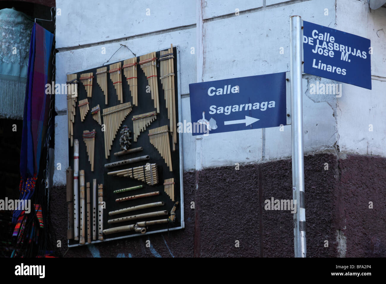 Sign for Witches Market on corner of Calles Sagarnaga and Linares, musical instruments hanging on wall behind, La Paz, Bolivia. Stock Photo