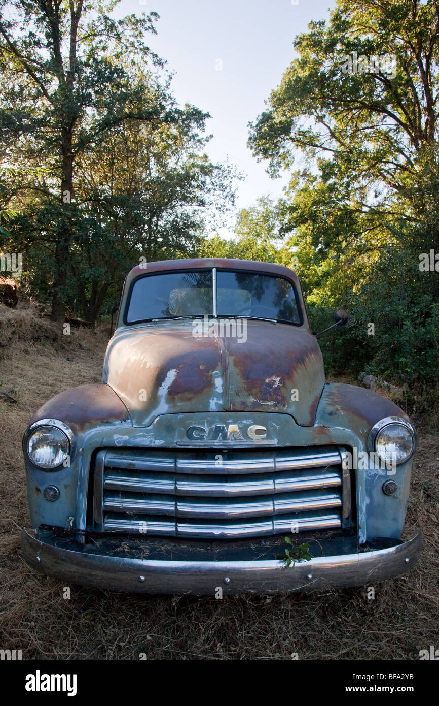 Rusting early 1950's GMC pickup truck in a backyard Stock Photo