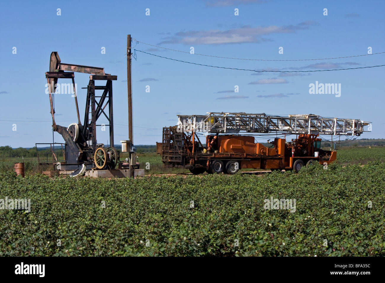 Oil well pump with oil  service truck in a cotton field in the Texas Panhandle. Stock Photo