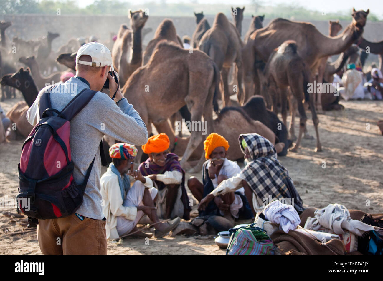 Tourist photographing Rajput men at the Camel Fair in Pushkar India Stock Photo