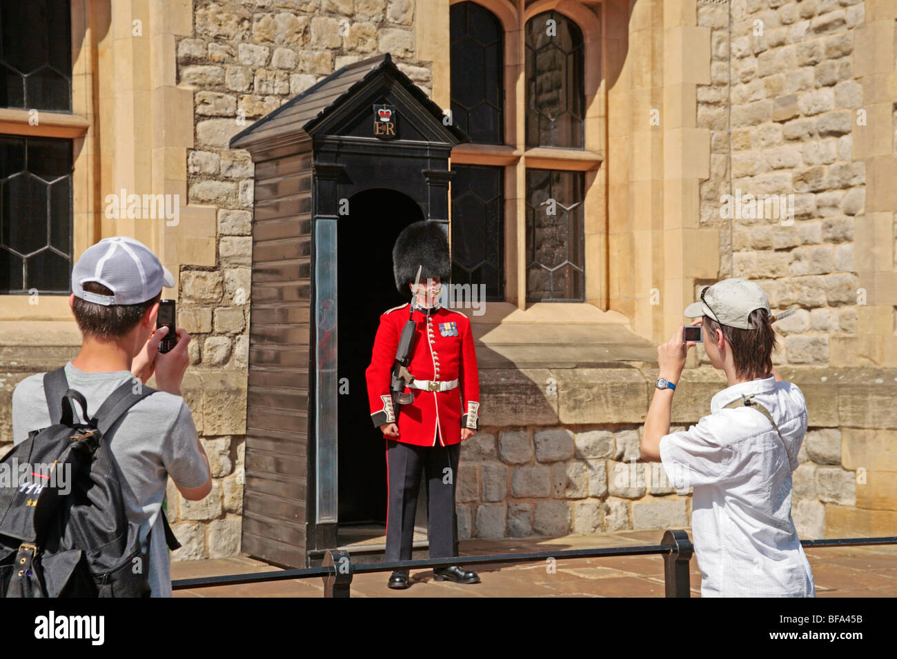 teenage boys taking a photo of a Guard at Waterloo Barracks at the Tower of London, Great Britain Stock Photo