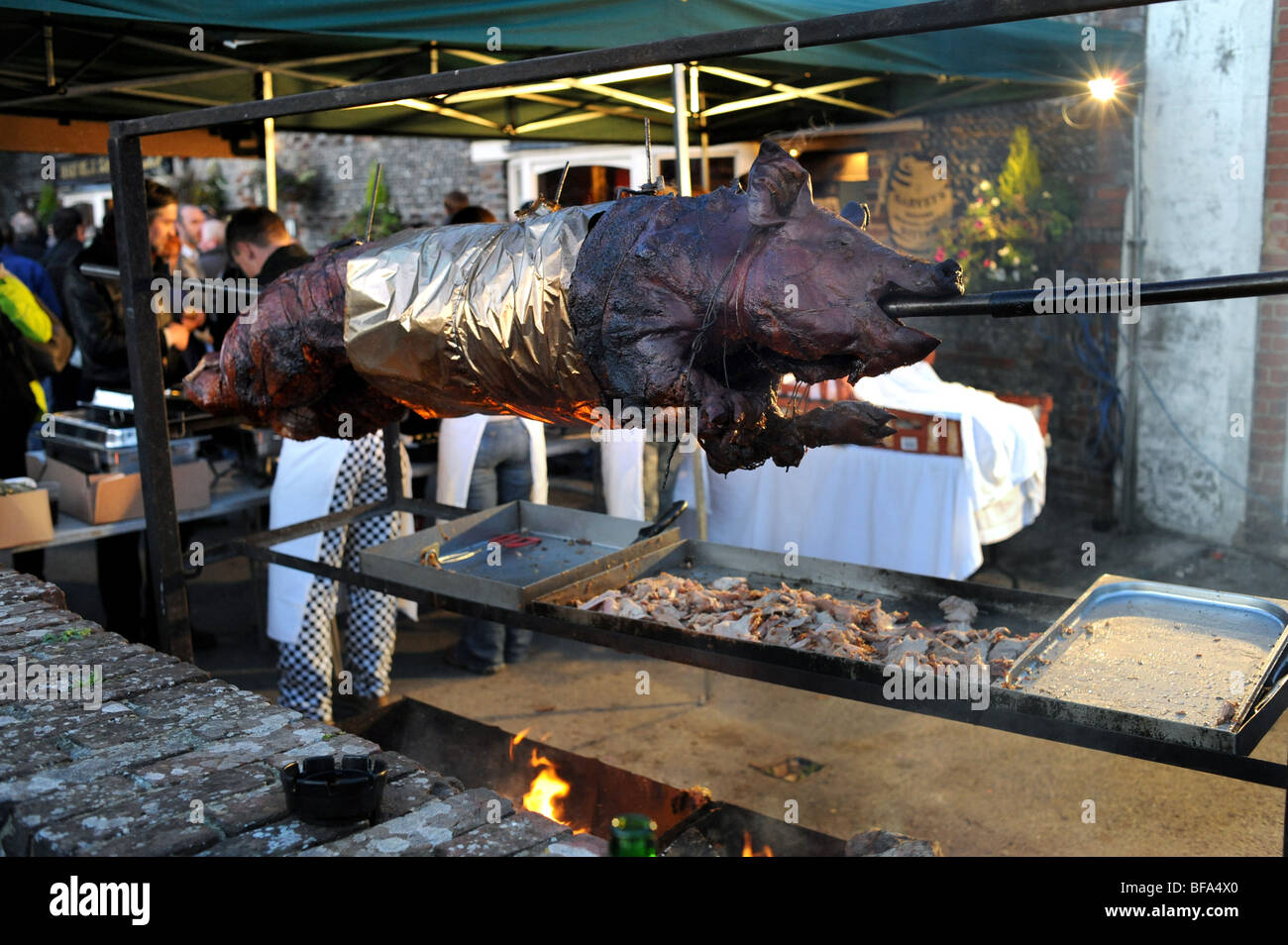 Pork hog roast on a spit over a fire at the Lewes Bonfire Party celebrations UK Stock Photo