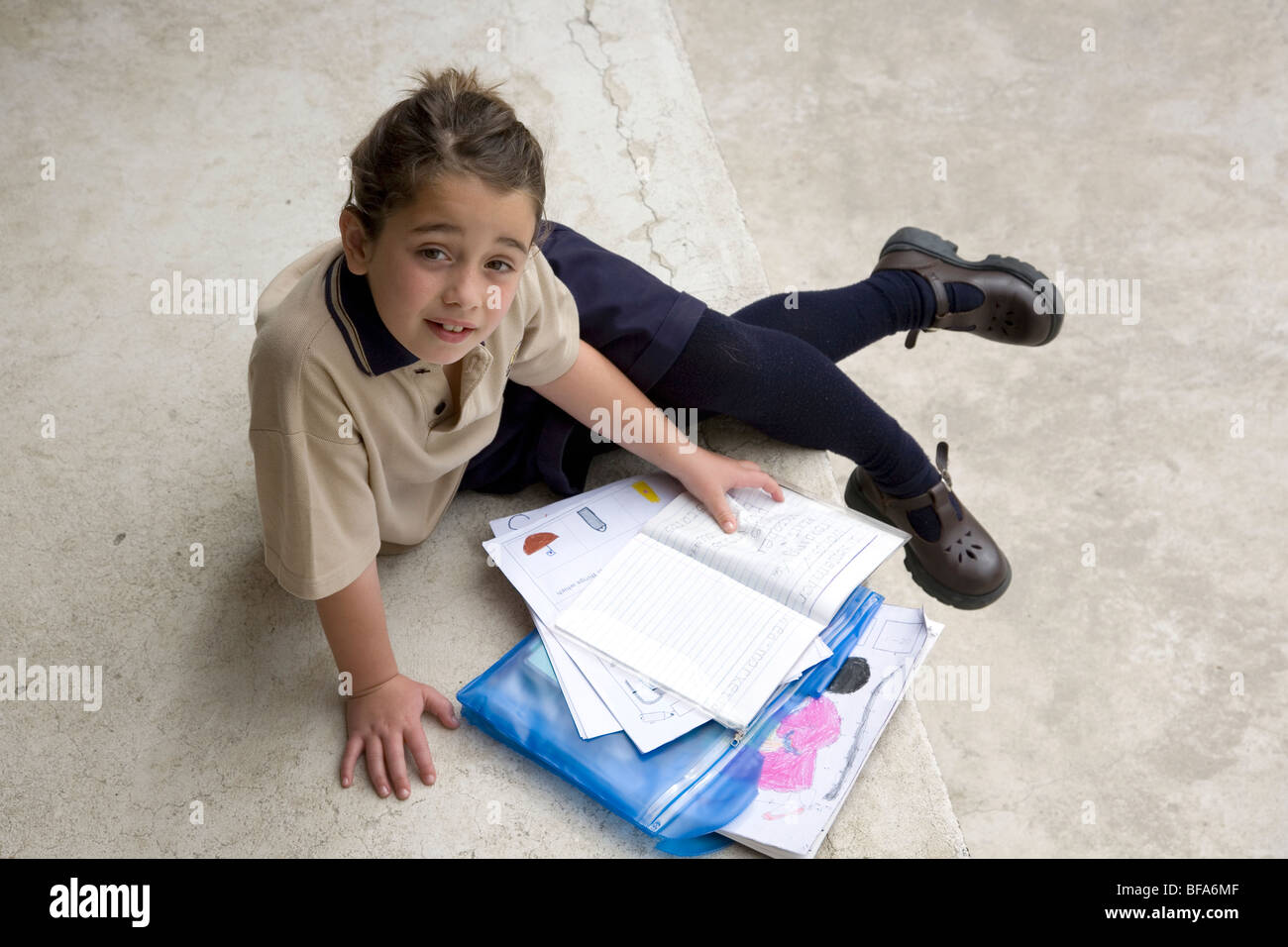 Schoolgirl looking through homework Stock Photo - Alamy