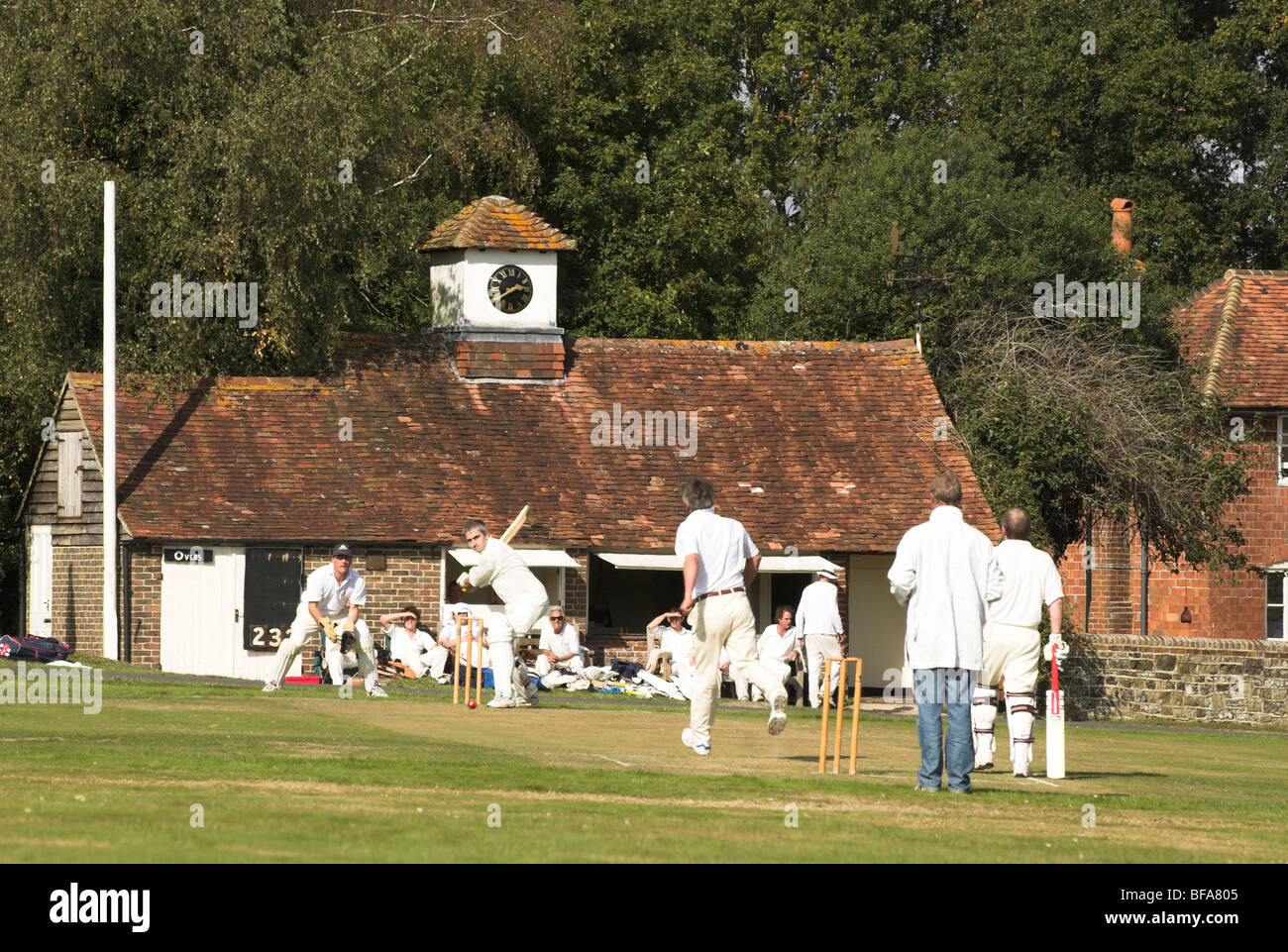 Lurgashall village green sees players participating in a game of cricket on a warm sunny autumn day. Stock Photo