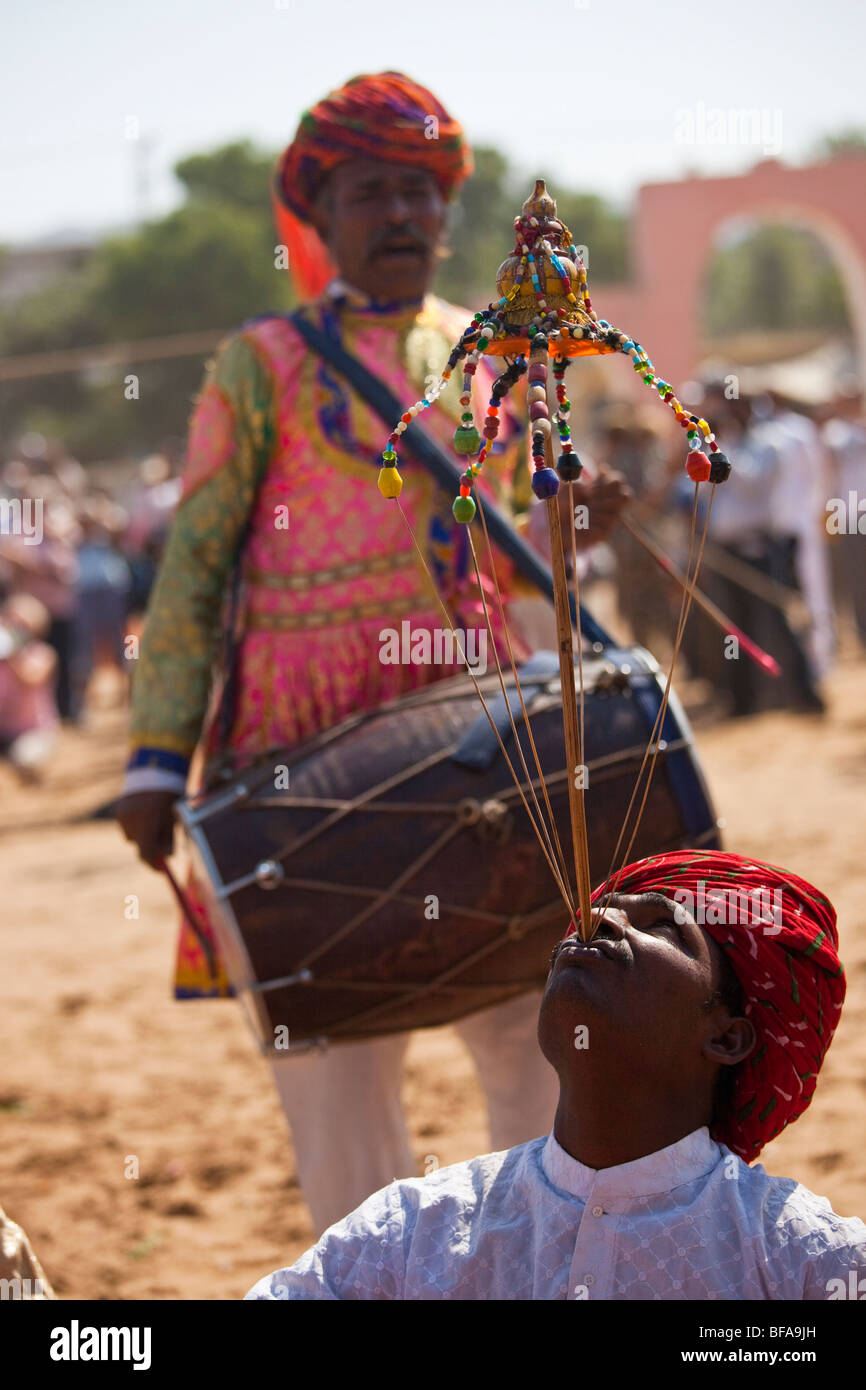 Balancing act at the Camel Fair in Pushkar India Stock Photo