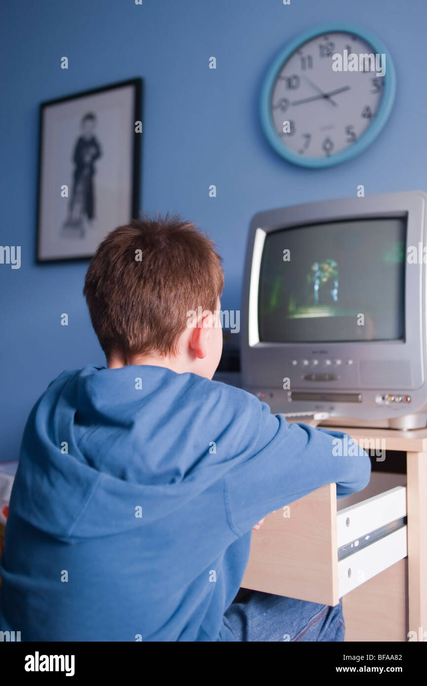 A Model Released picture of a ten year old boy watching tv in his bedroom in the Uk Stock Photo