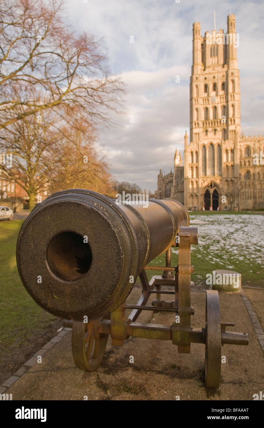 ancient canon on the green at Ely Cathedral with the cathedral in the background and snow on the ground Stock Photo