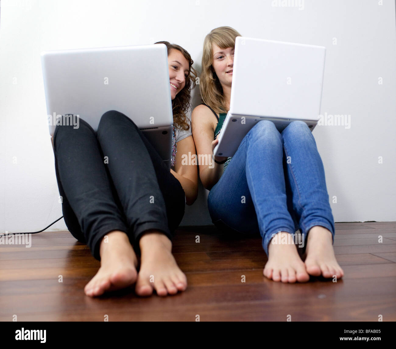 Friends sitting on the floor with notebooks Stock Photo