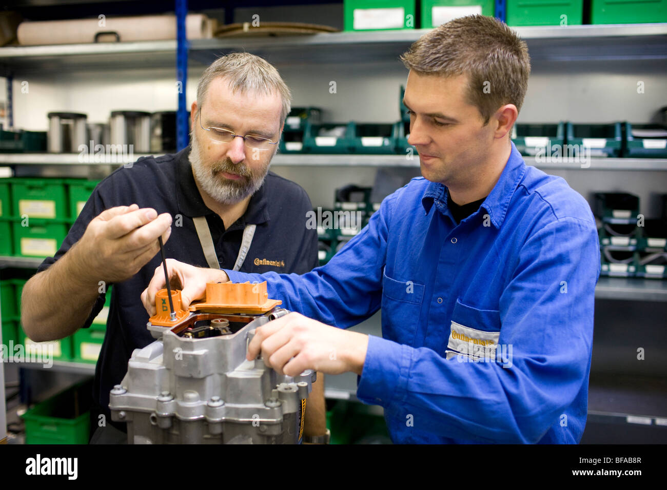 Zwei Mitarbeiter von Continental montieren ein Achsgetriebe fuer ein Elektrofahrzeug. Stock Photo