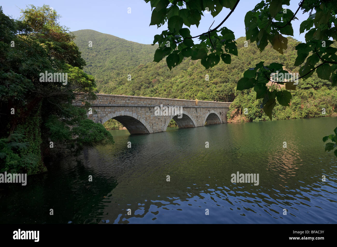 A stone bridge over a reservoir in Tai Tam Country Park in Hong Kong. Stock Photo