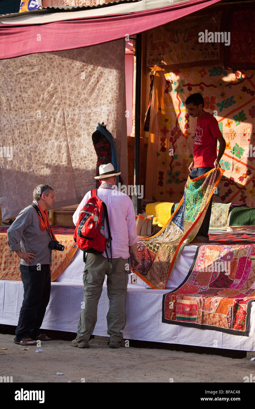 Gay tourists shopping for a sparkly blanket during the Camel Fair in Pushkar India Stock Photo