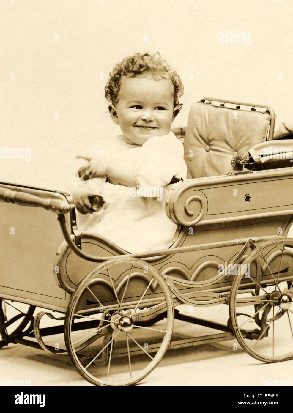 Cute Baby in Decorative Pedal Car Stock Photo