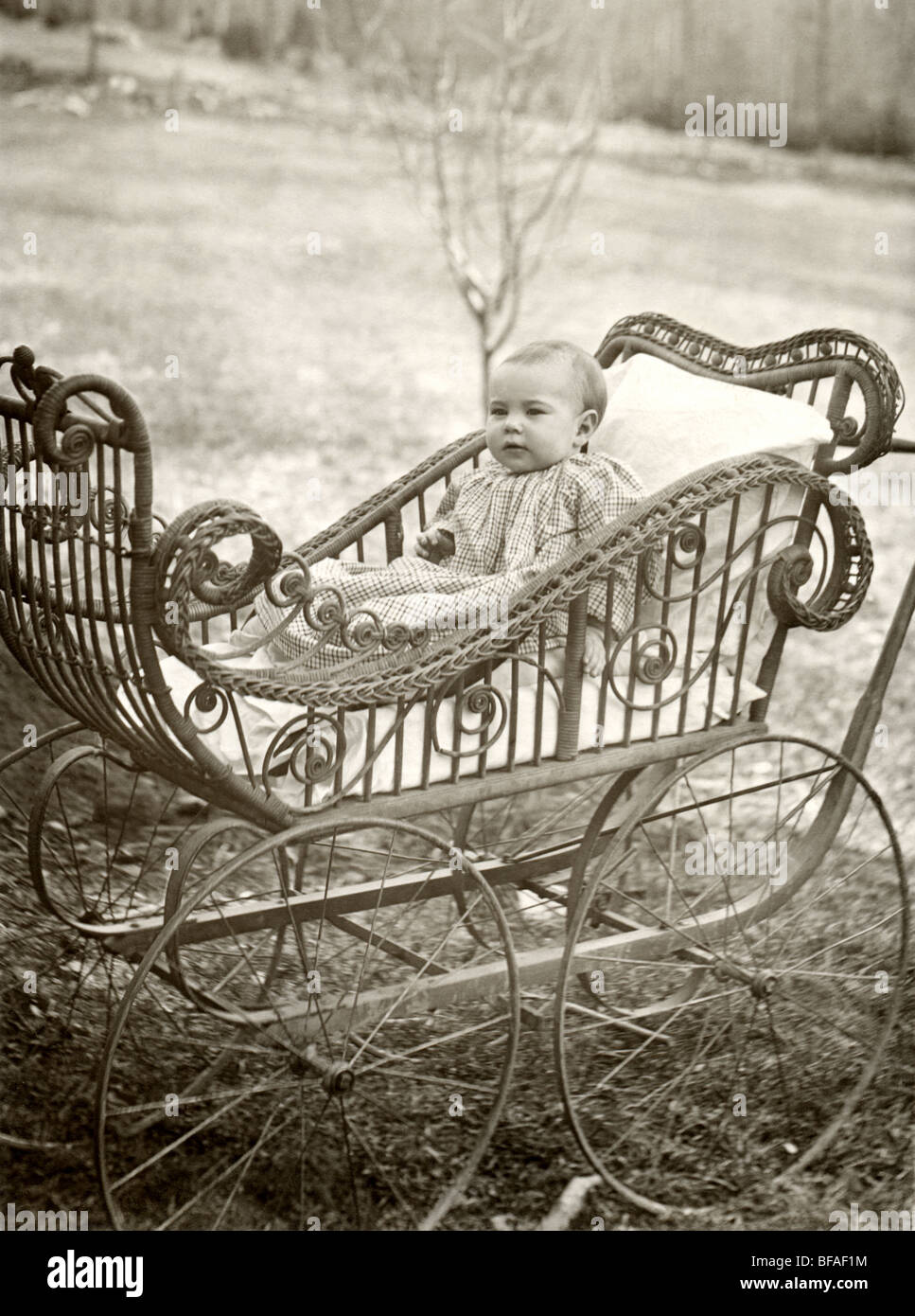 Infant in Exceptional Wicker Baby Carriage Stock Photo