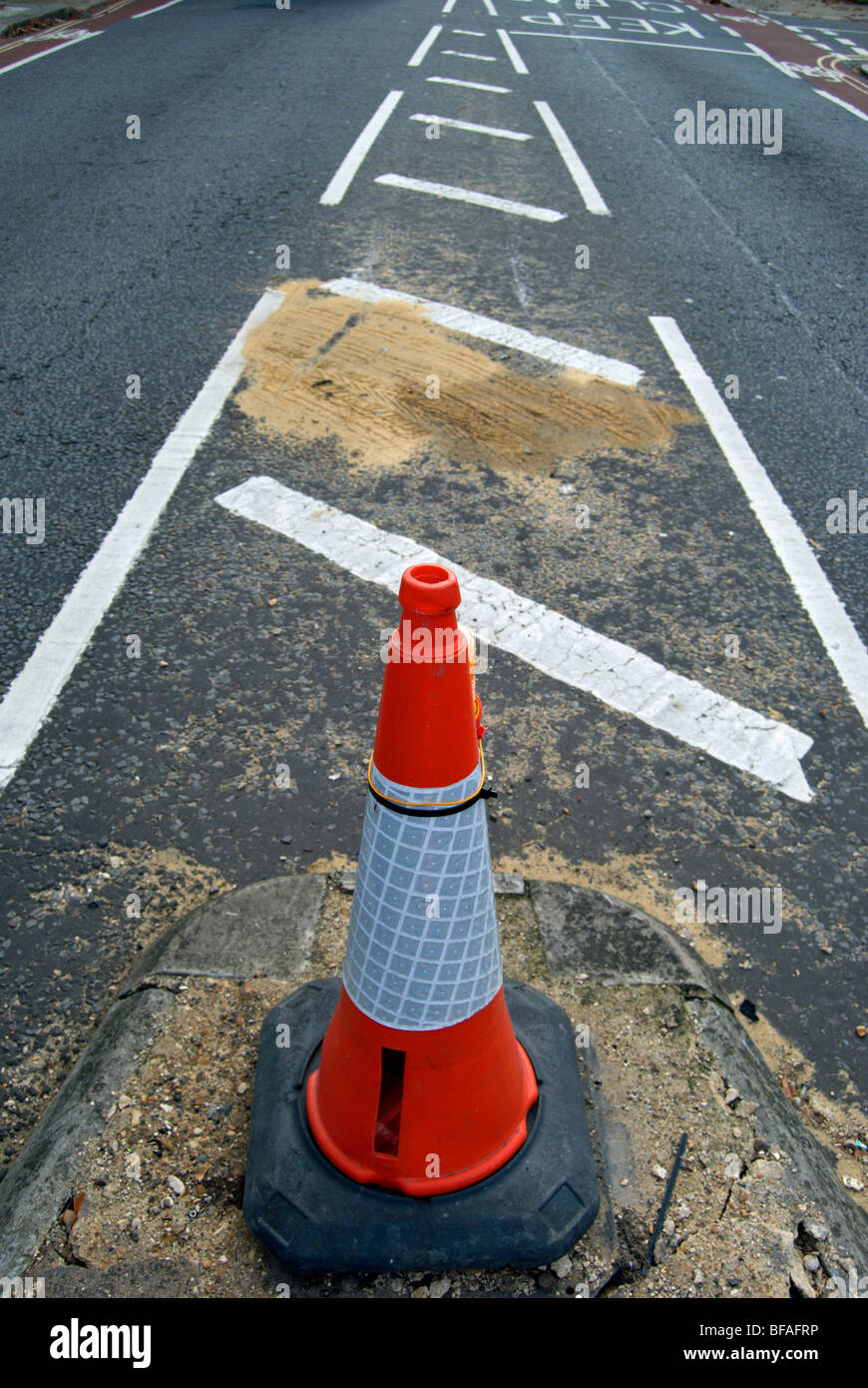 traffic cone marking a damaged section of road in teddington, middlesex, england Stock Photo