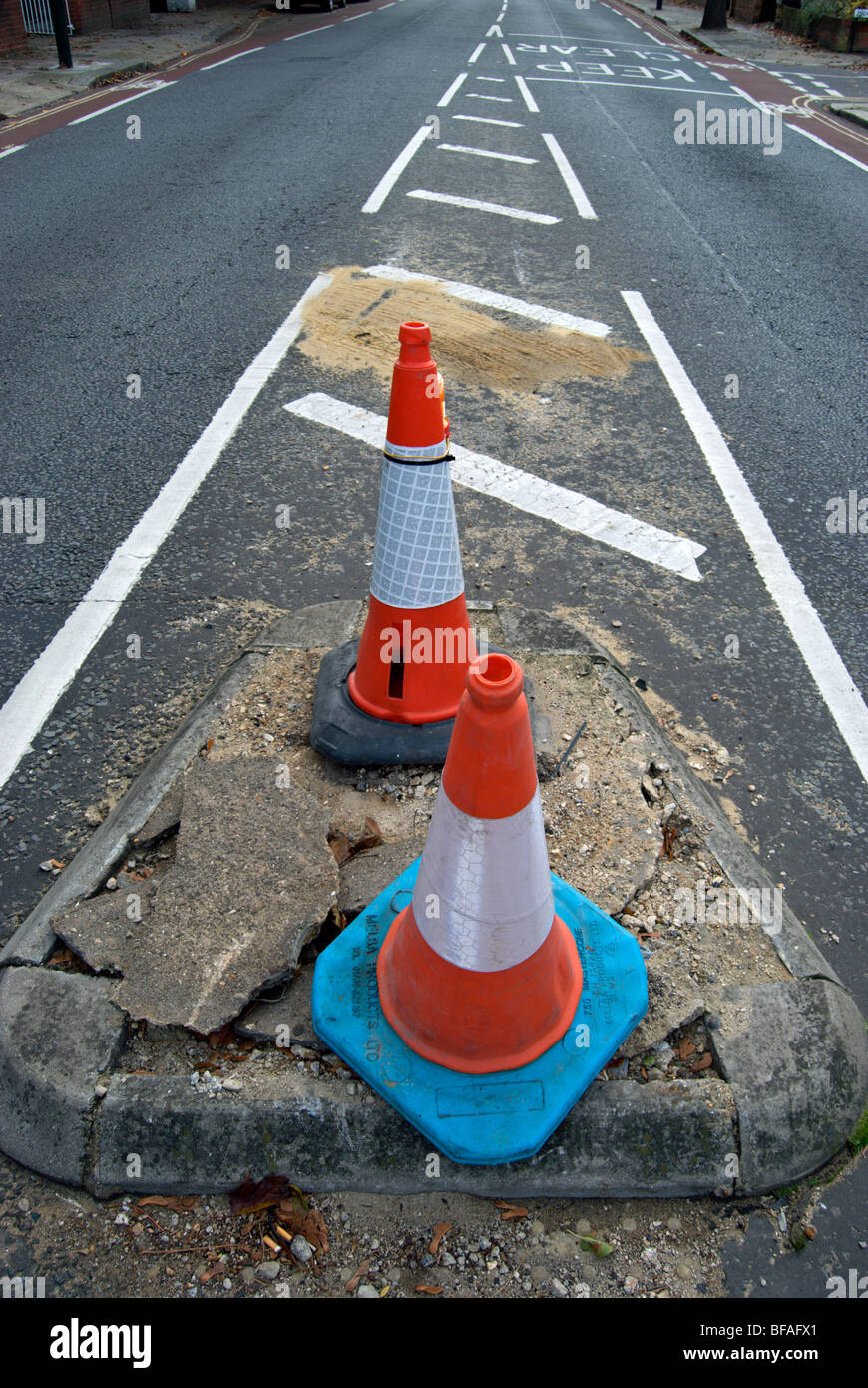 two traffic cones marking a damaged section of road in teddington