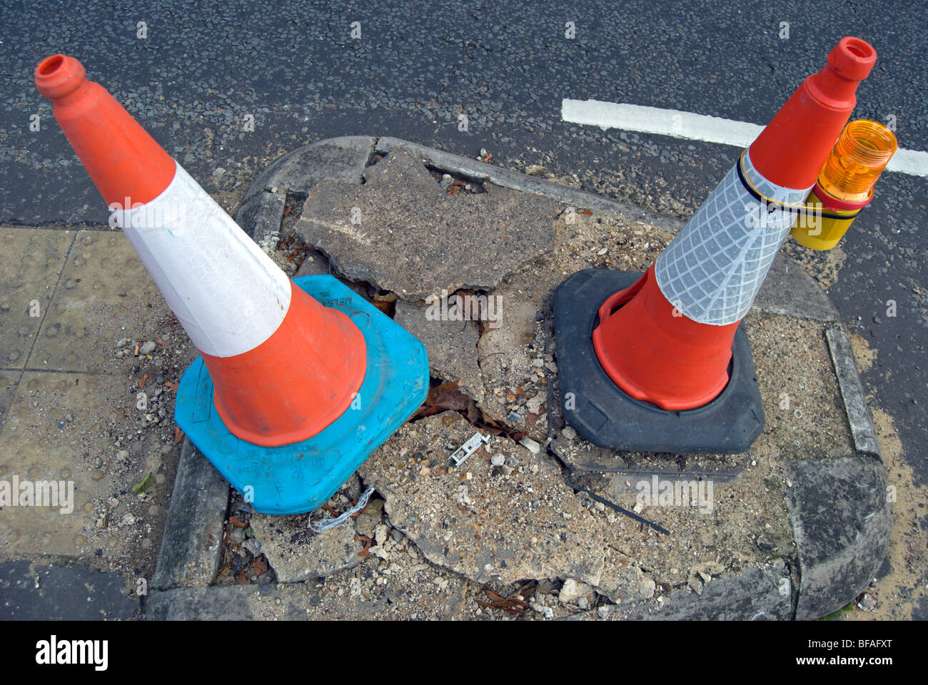 two traffic cones marking a damaged section of road in teddington, middlesex, england Stock Photo