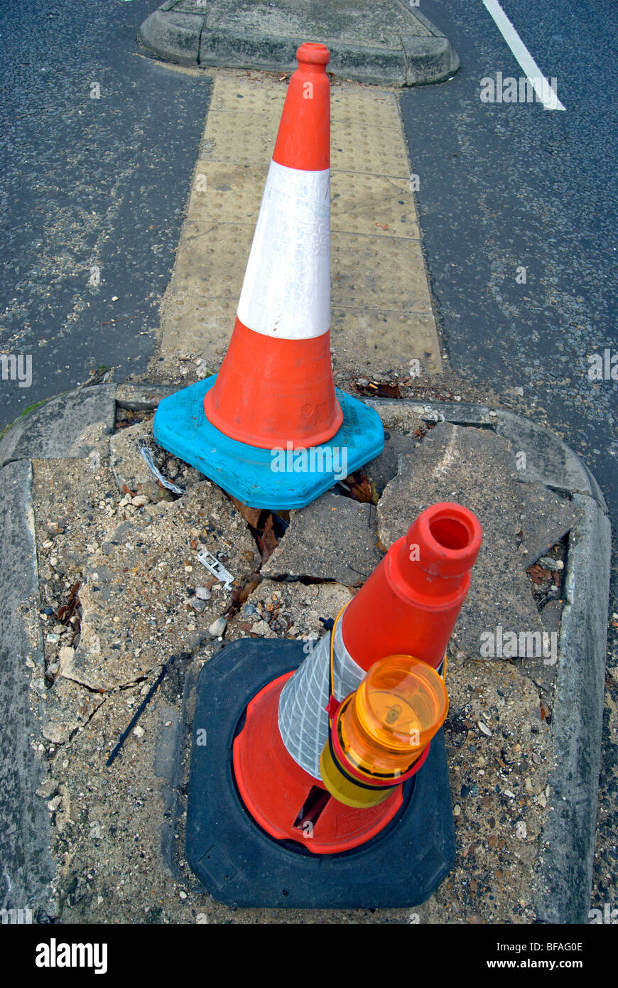 two traffic cones marking a damaged section of road in teddington, middlesex, england Stock Photo