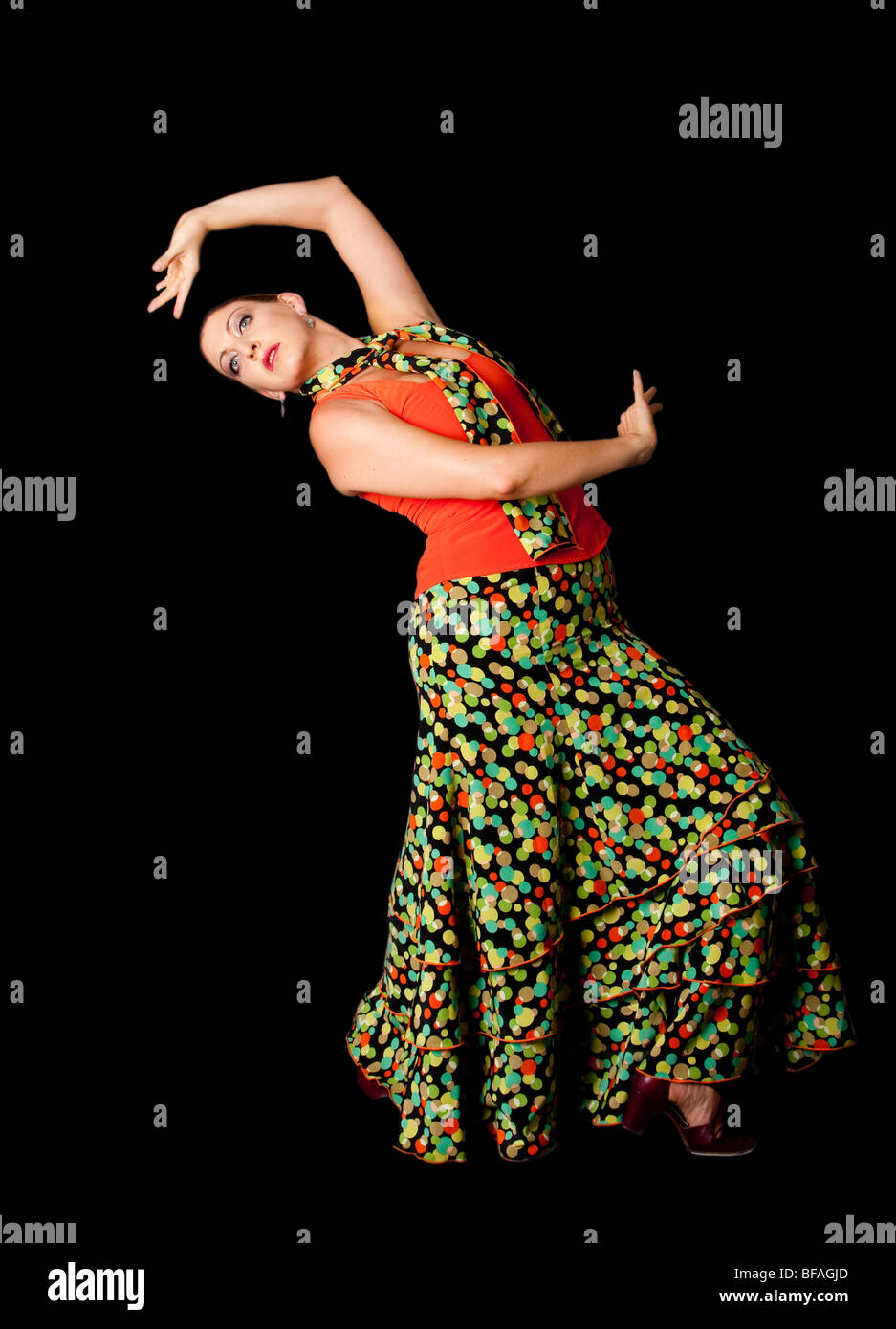 Beautiful modern Spanish Caucasian Flamenco and Paso Doble dancer wearing a colorful skirt with polka dots and orange shirt. Stock Photo