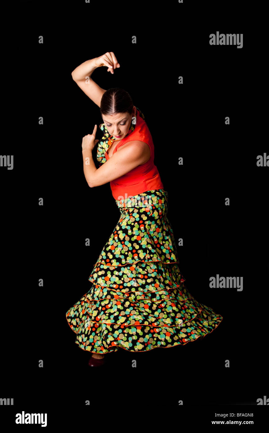 Beautiful Spanish Caucasian Flamenco and Paso Doble dancer wearing a colorful skirt with polka dots and orange shirt. Stock Photo