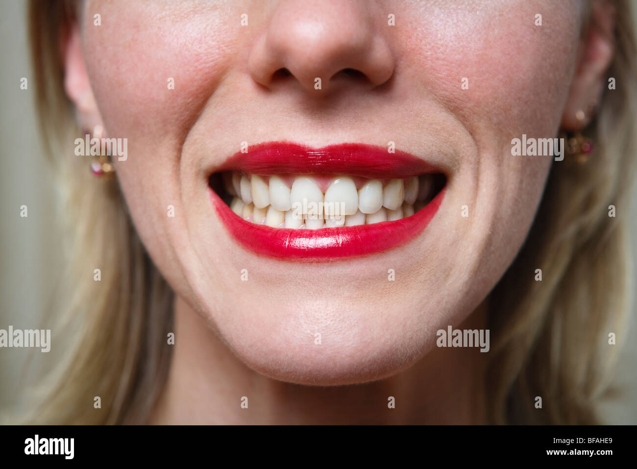 Woman smiling widely, probably insincerely Stock Photo