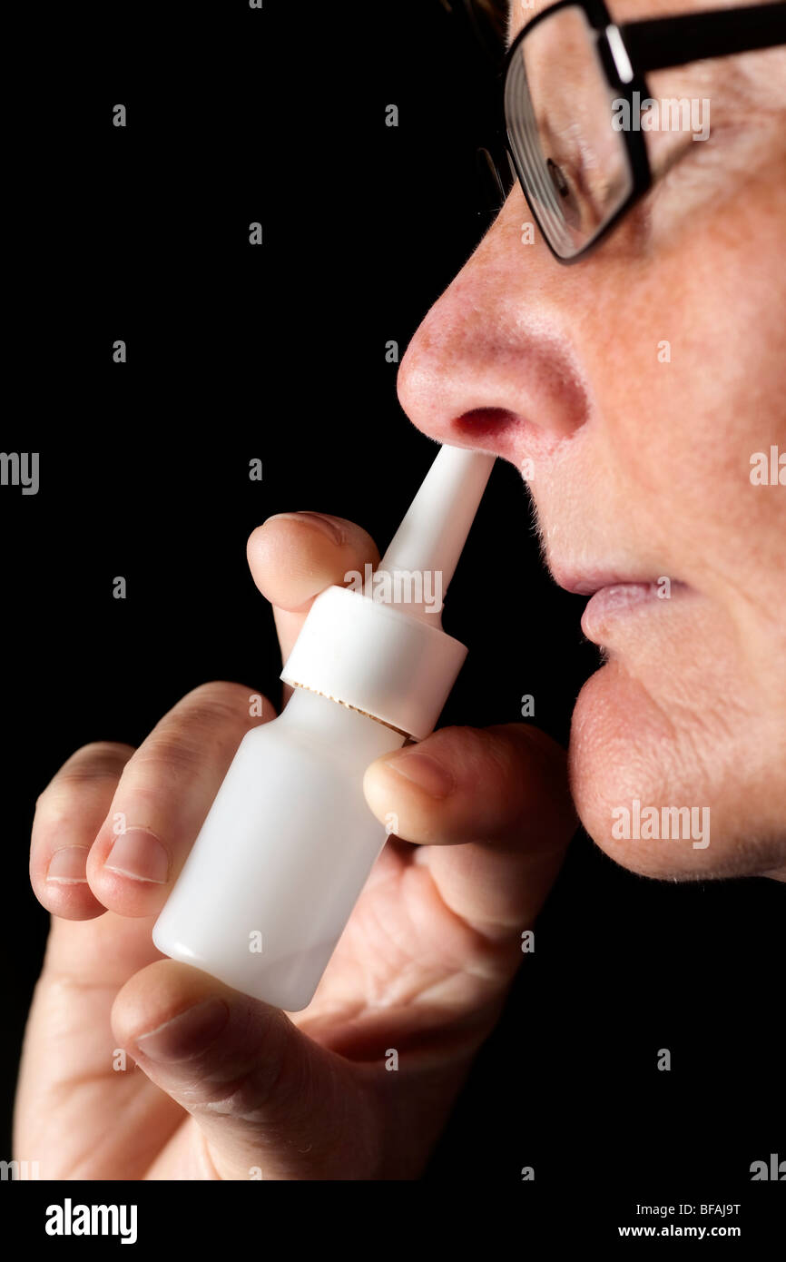 Woman using nose spray. Stock Photo