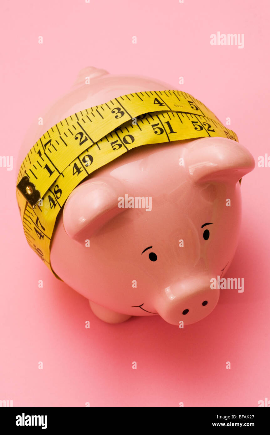 Pink piggy bank wrapped with a tape measure Stock Photo Alamy