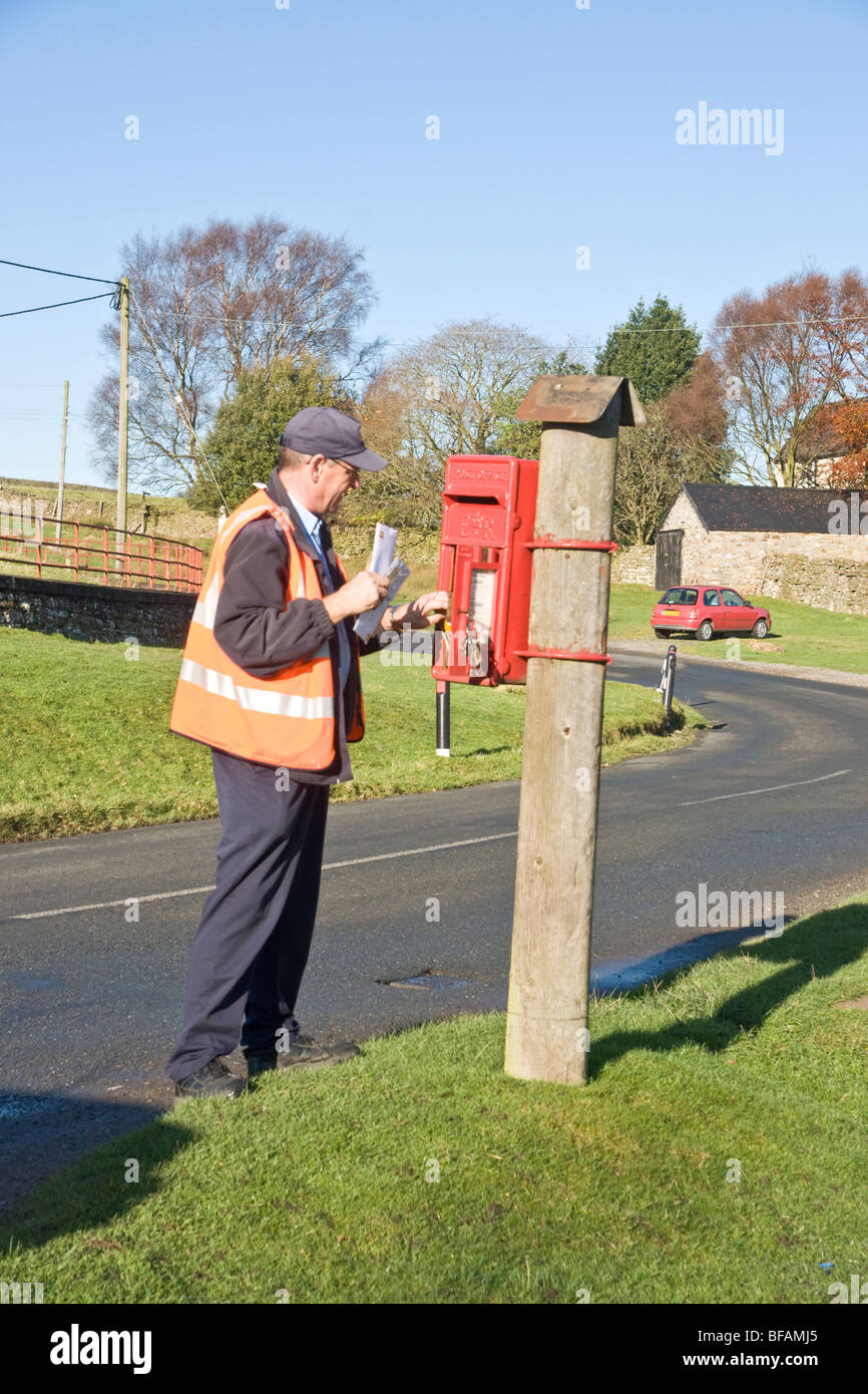 Postman collecting letters from a rural post box near Reeth, Swaledale. Stock Photo