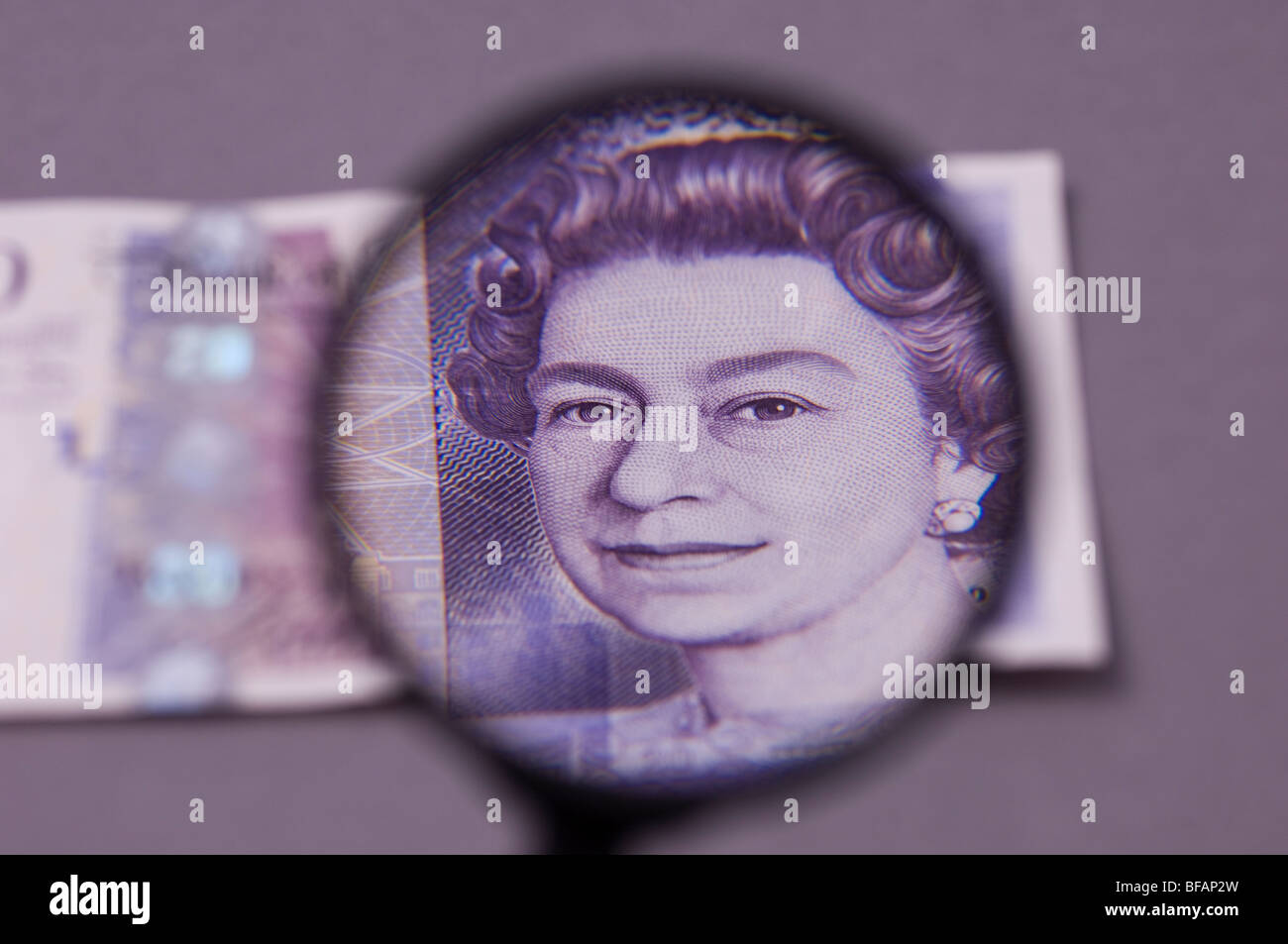 British money and a magnifying glass Stock Photo Alamy
