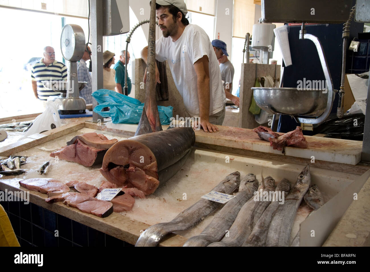 Fishmonger on stall in indoor fish market, Lagos, Portugal Stock Photo