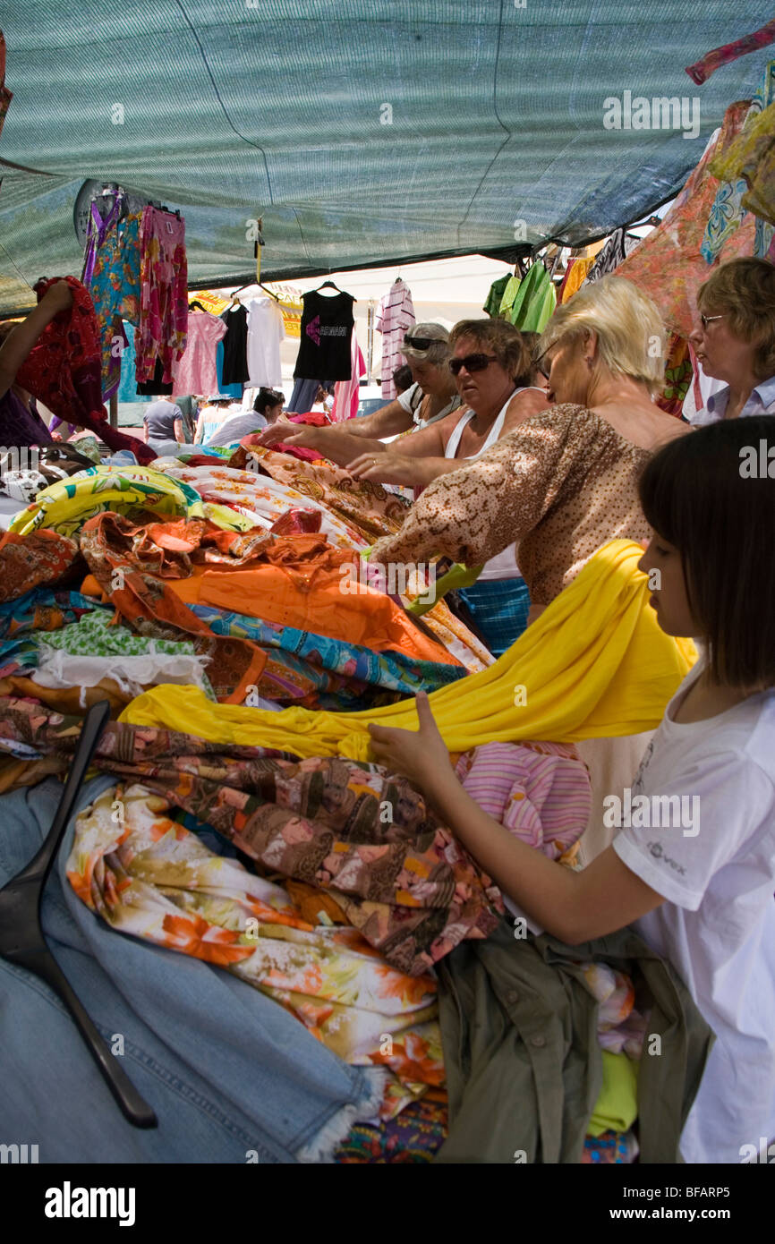 Women buying Indian clothes on open air market stall in Lagos Stock