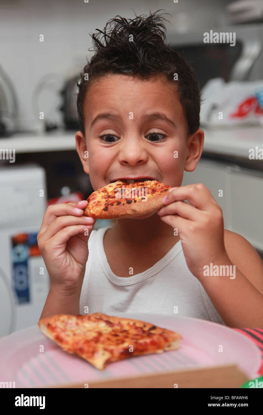 6 year old boy eating pizza Stock Photo
