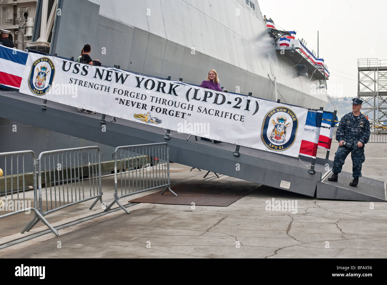 Navy crew member on duty at decorated gangplank permitting the public to visit USS New York moored at Pier 88 in New York City Stock Photo
