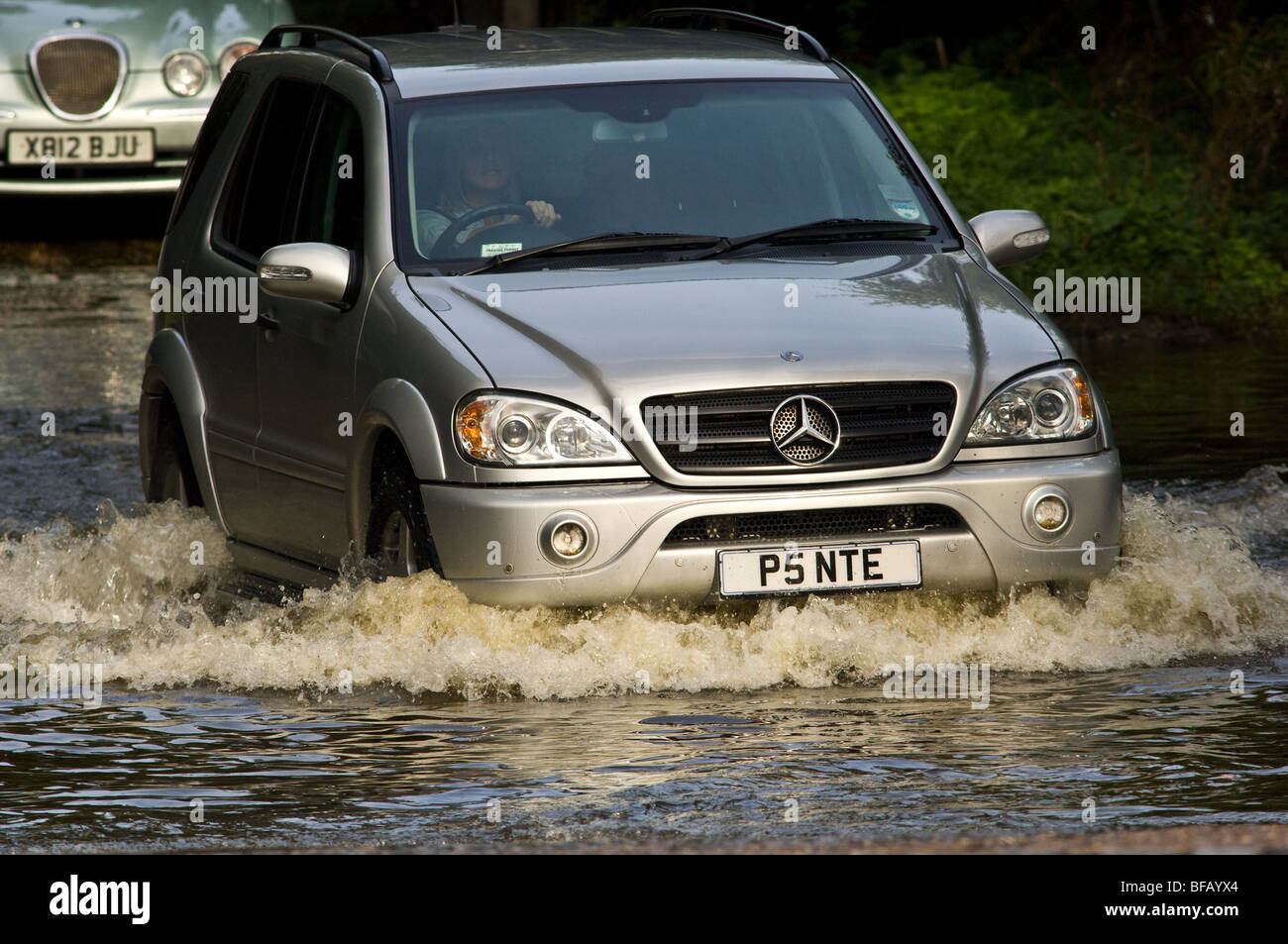 Motor vehicles driving through a flooded weir Stock Photo