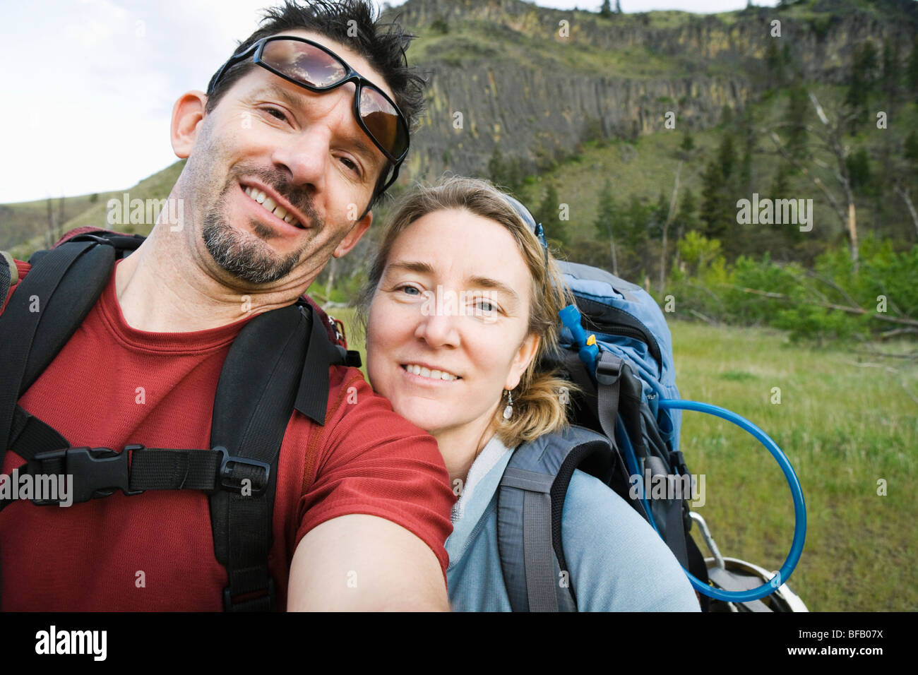 A middle aged couple wearing backpacks making a self portrait in the Tieton River Canyon, Eastern Washington, Cascades, USA. Stock Photo