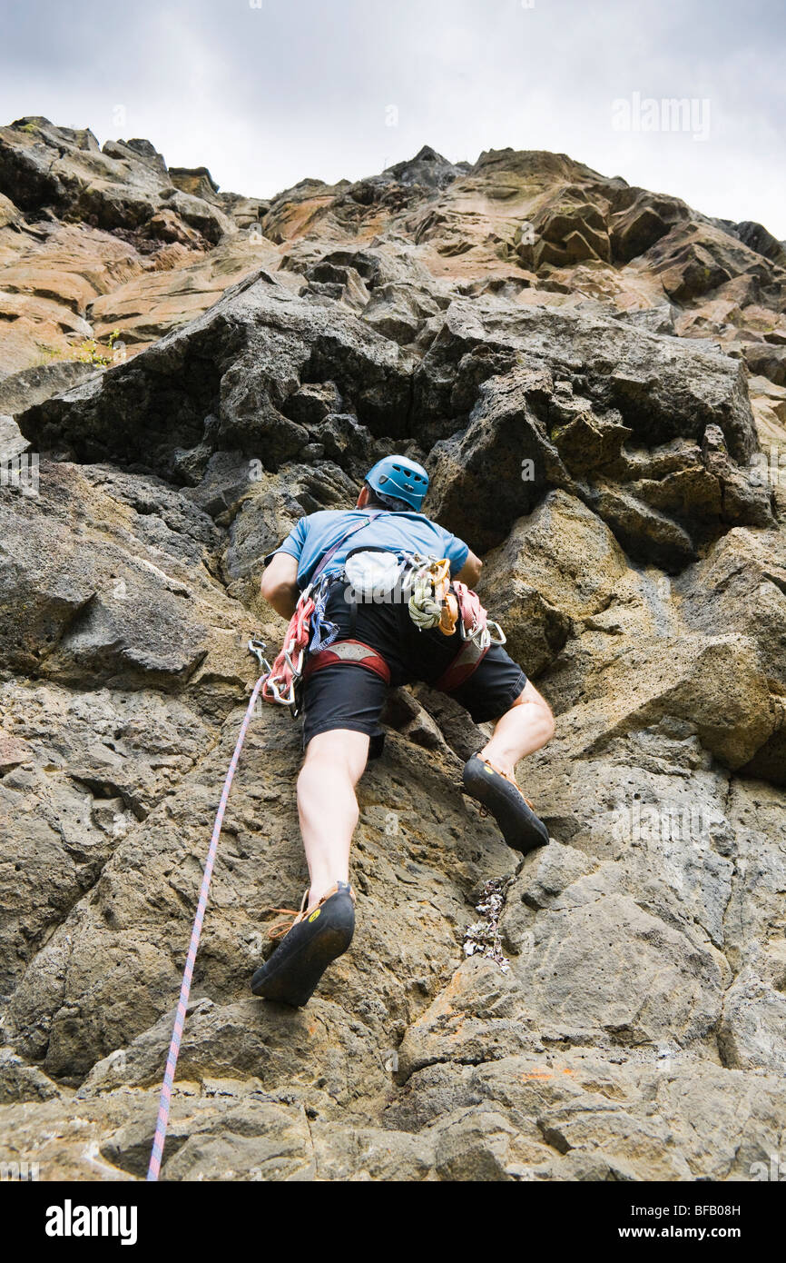 A male rock climber making his way up a steep rock wall. Lava Point