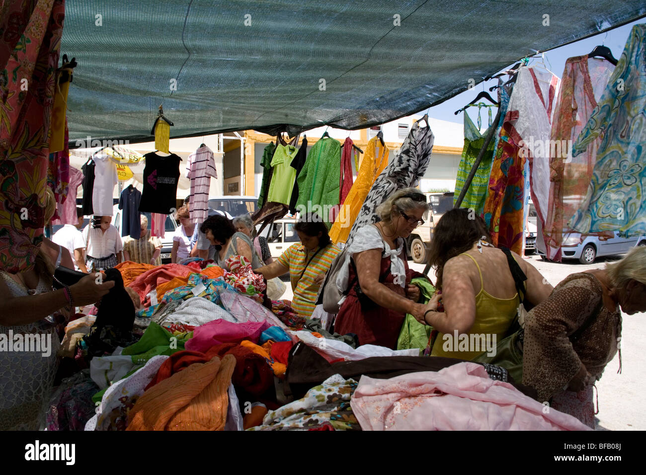 Women buying Indian clothes on open air market stall in Lagos, Portugal
