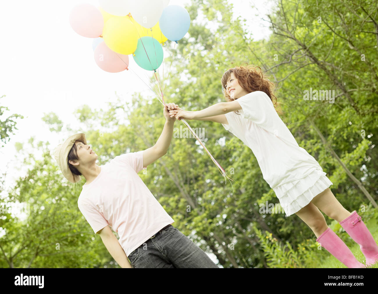 Young couple holding balloon Stock Photo - Alamy