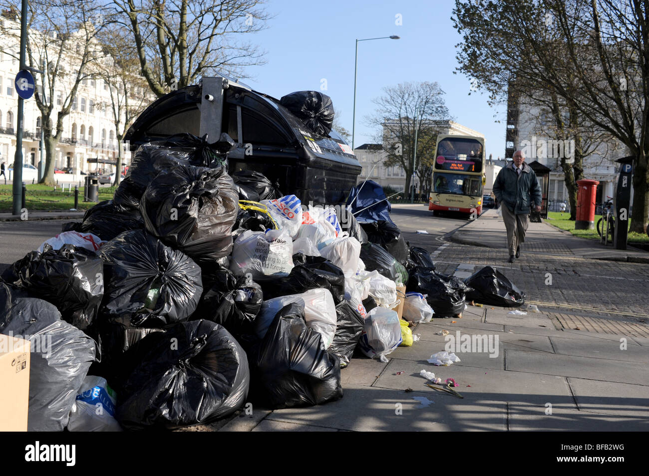 Uncollected rubbish and refuse spilling over on to the road and