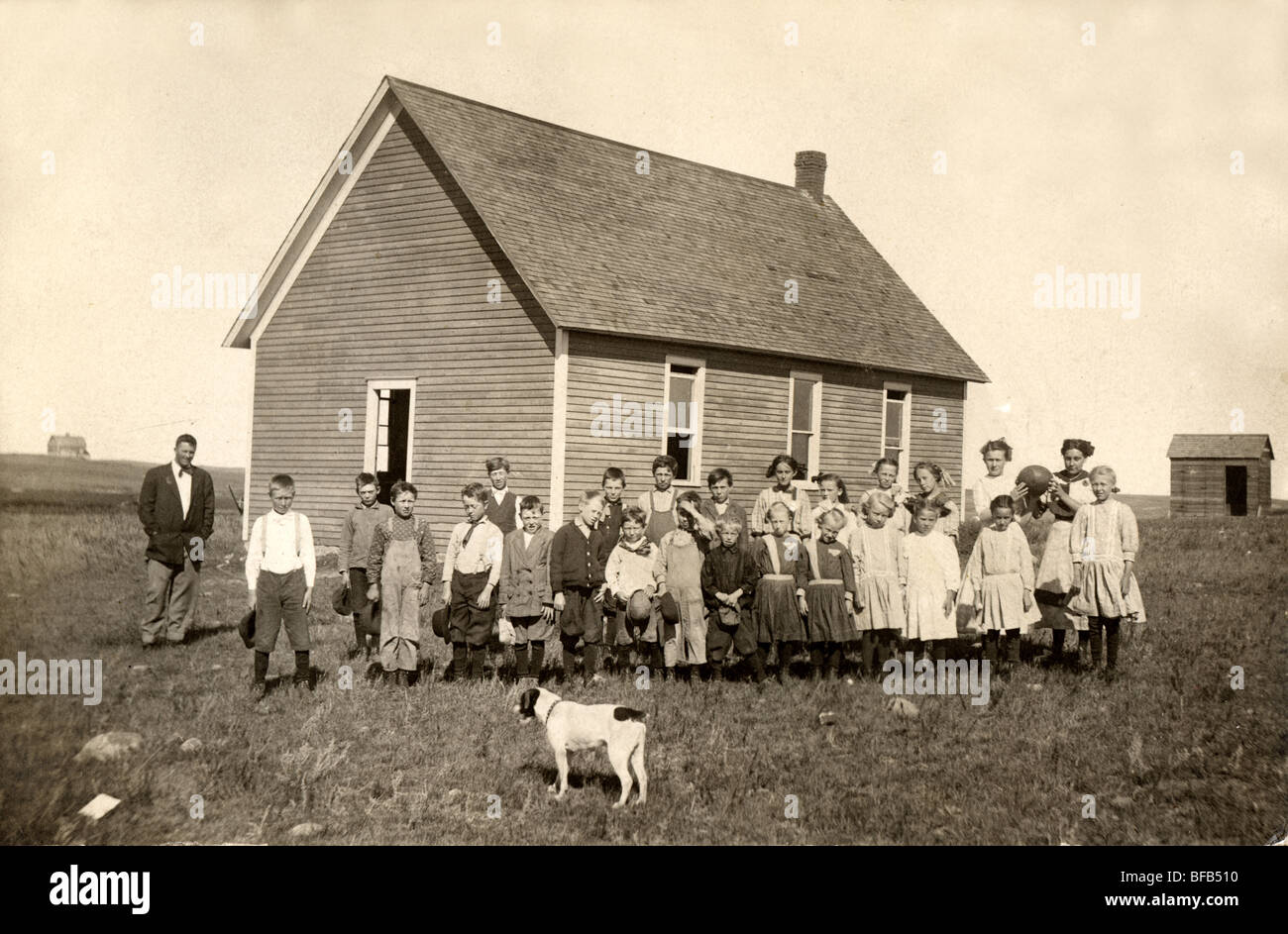 Dog Inspecting Students at One Room Schoolhouse Stock Photo