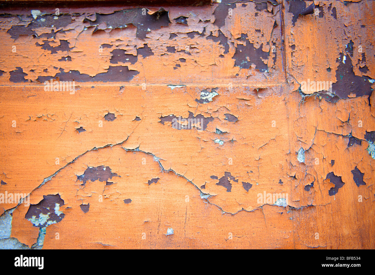 Close up of peeling orange paint on a wall Stock Photo