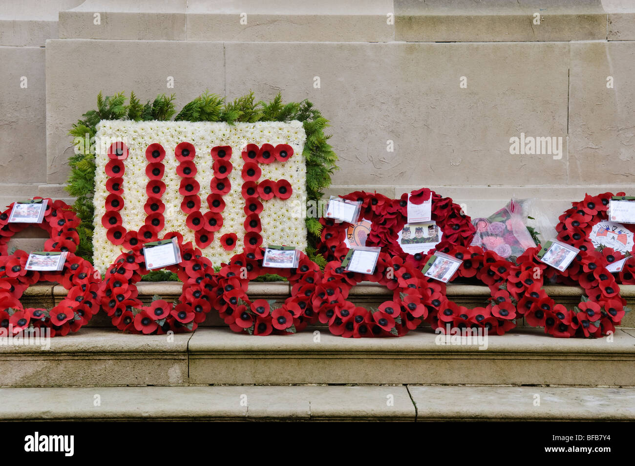 Poppy weaths on the steps of the cenotaph, along with a large Ulster Volunteer Force/UVF wreath Stock Photo