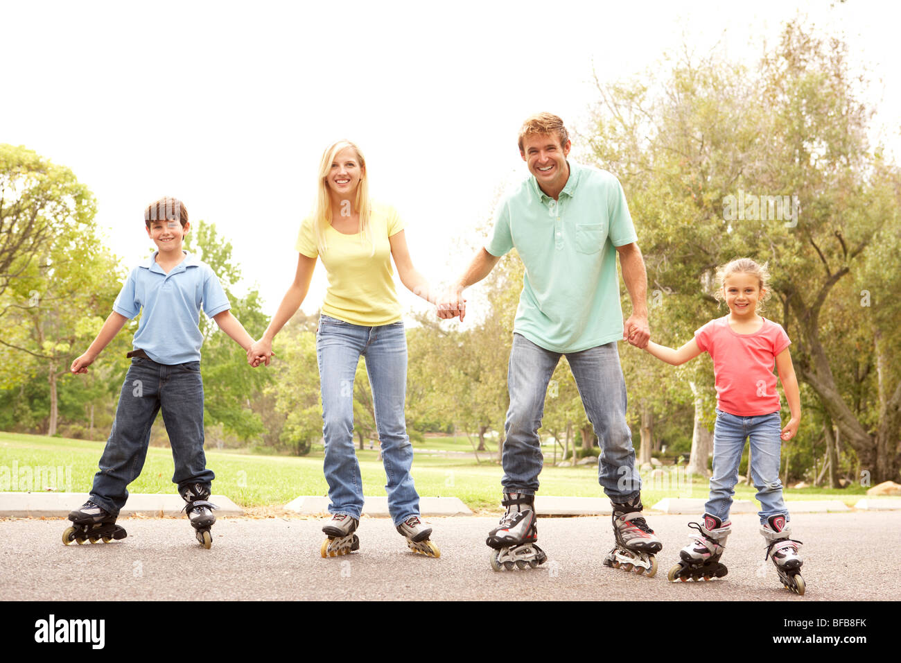 Family Wearing In Line Skates In Park Stock Photo