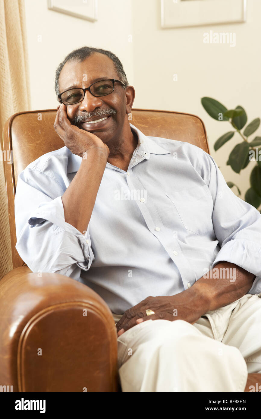 Senior Man Relaxing In Chair At Home Stock Photo - Alamy
