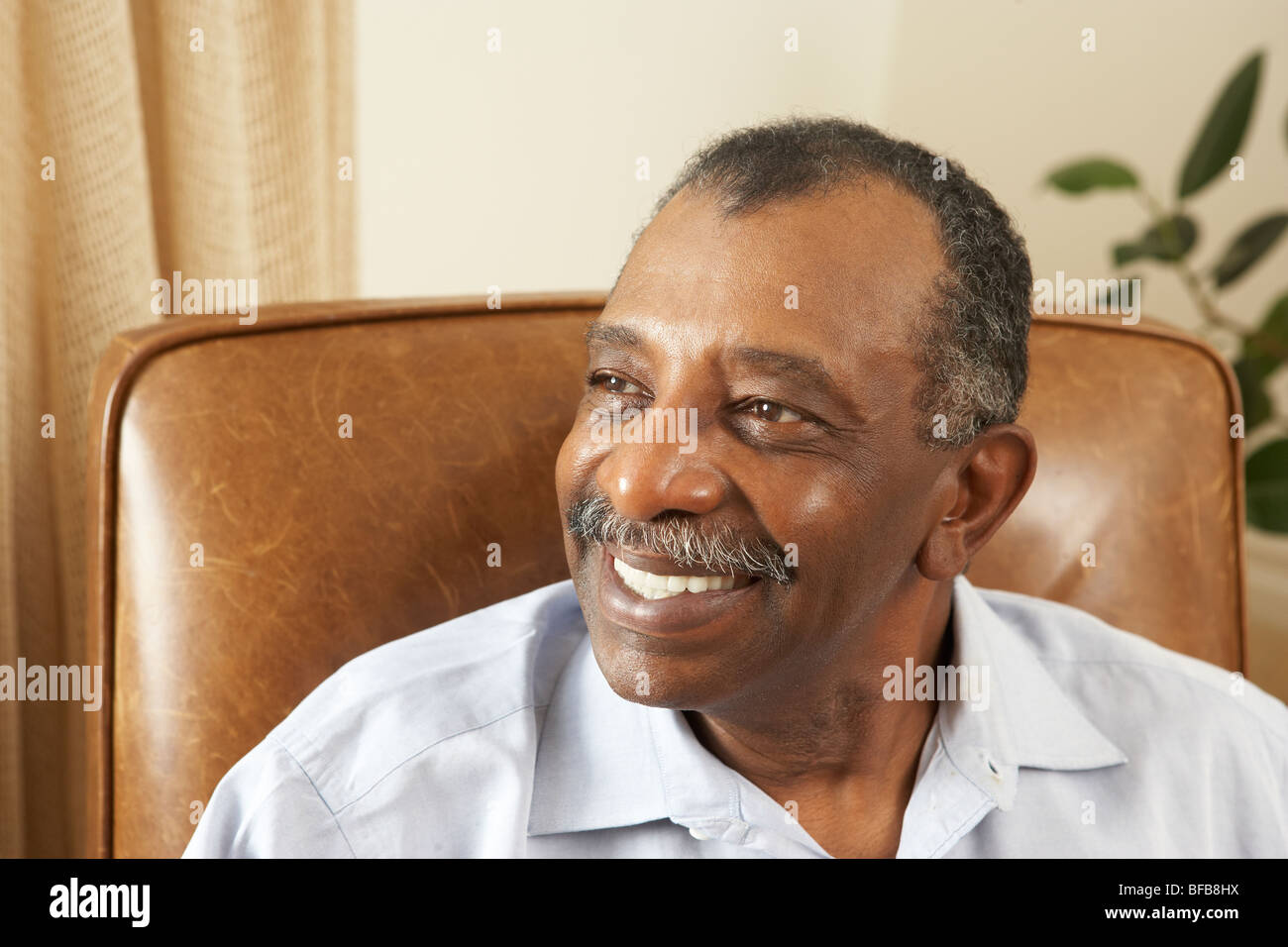 Senior Man Relaxing In Chair At Home Stock Photo - Alamy