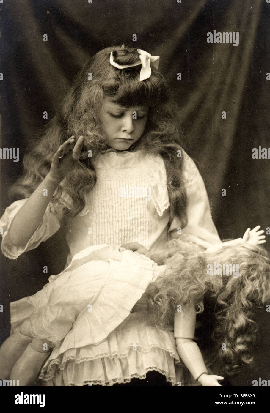 Little Girl Punishing Her Doll Stock Photo