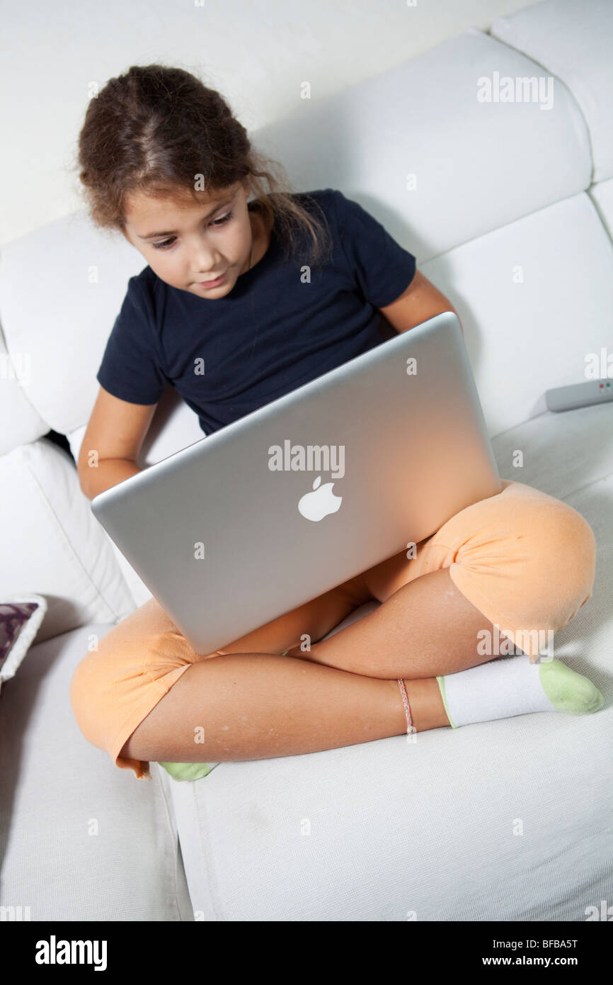 Young schoolgirl working on her mac laptop at home Stock Photo - Alamy