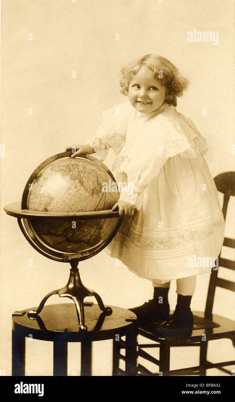 Little Girl Gripping a Large Globe Stock Photo